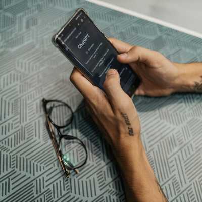 Persona sosteniendo un teléfono con ChatGPT abierto en la pantalla.